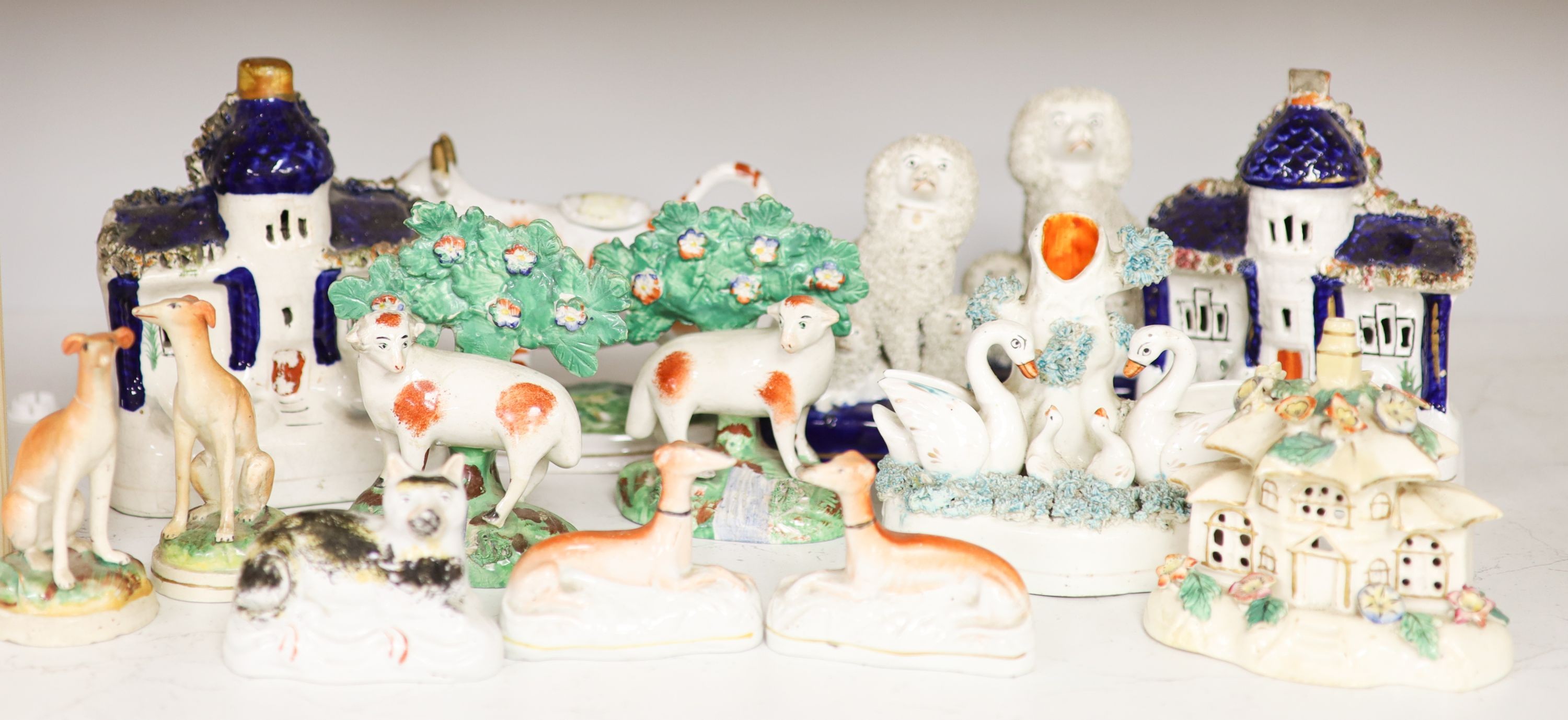 A collection of Victorian Staffordshire pottery to include a sponge glazed seated cat, a pair of bocage sheep, cow creamer etc (14).